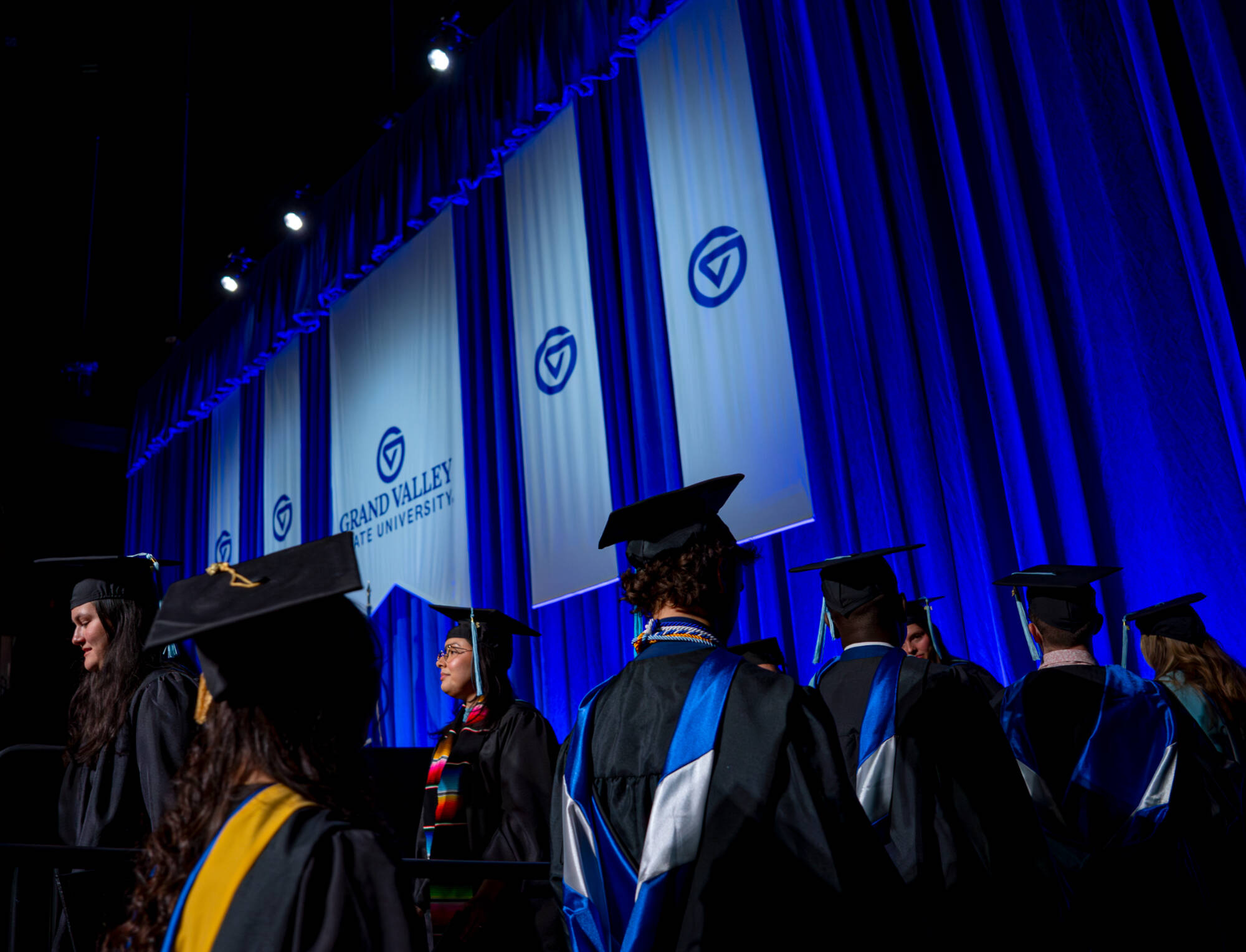 Students walking up to the stage to receive their diploma at commencement ceremony